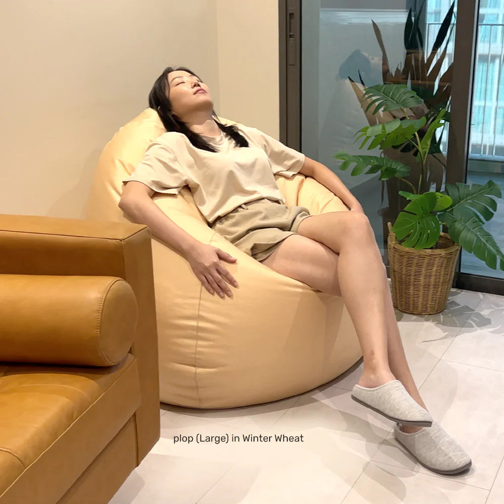 person sleeping ona large teardrop bean bag chair