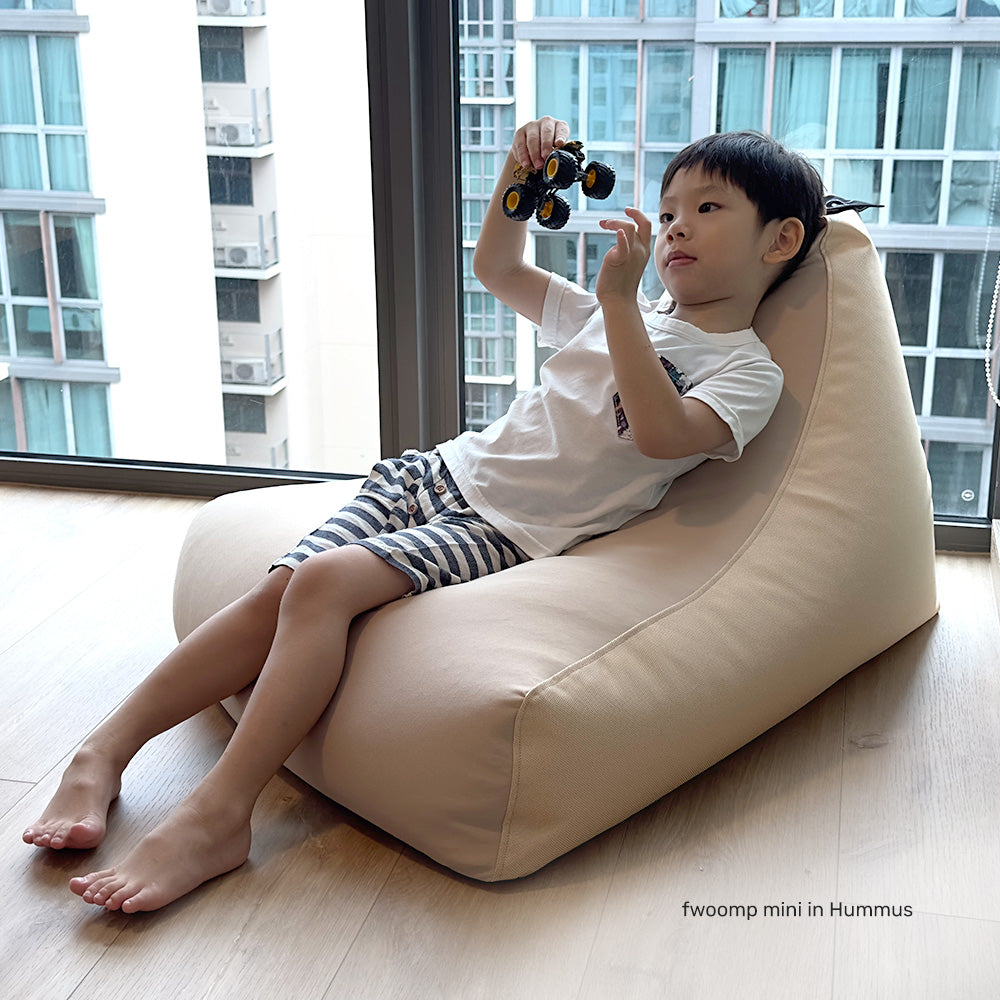 young boy relaxing on a spandex bean bag lounger in a kids room